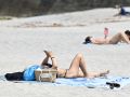 Una persona toma el sol en la playa del Orzán
