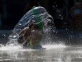 Dos niños se refrescan en un parque de Torrelavega