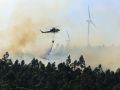 Un helicóptero descarga agua sobre un incendio forestal en la localidad coruñesa de Padrón el 13 de junio