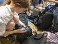 Varias alumnas guardan sus móviles en las mochilas antes de realizar un examen