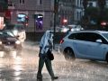 Una mujer trata de protegerse de la lluvia, la última jornada mojada del verano