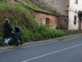 Una mujer camina con un carrito por la Rúa Amil