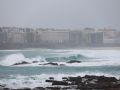 Surfistas en la playa en medio de una alerta naranja