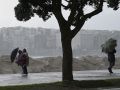 Varias personas se protegen de la lluvia junto a la costa de A Coruña
