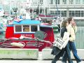 Hace 25 años | Una boya estadounidense recorre 9.000 kilómetros hasta A Coruña Dos personas pasean frente a la dársena en una imagen de 2025