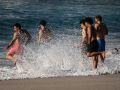 Varios jóvenes disfrutan de las altas temperaturas, esta tarde, en la playa del Orzán