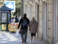 Dos personas, con ropa deportiva, caminan por el centro de la ciudad