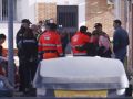 Agentes de la Policía Nacional y efectivos de emergencias, este lunes, a las puertas del edificio donde tuvo lugar el feminicidio