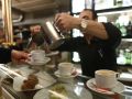Un camarero sirve un café con leche en un local de hostelería