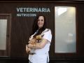 Ángela Vela posa con su perro delante de la clínica Avela Nutrición Veterinaria
