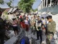 Un grupo de personas y soldados del Ejército de Filipinas contemplan un muro colapsado, un día después del terremoto