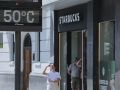Una mujer fotografía la temperatura en un termómetro de Bilbao el 24 de junio