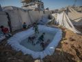 Niños refugiados de Gaza juegan en una piscina improvisada