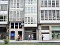 Varias personas caminan frente a la entrada del bloque de apartamentos en La Marina