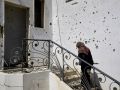 Una mujer iraní entra en su casa, marcada por los restos de un ataque de Israel