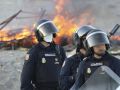 Presencia policial para evitar que continúen los incendios en las chozas constituidas por los migrantes en la playa del Trampolín este jueves en Ceuta. EFE/Reduan