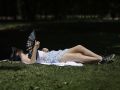 -Una joven descansa en el madrileño Parque del Retiro