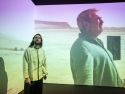 El director de ‘Sirat’, el gallego Oliver Laxe, durante un acto con un fotograma de la película de fondo
