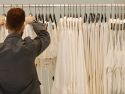 Un dependiente coloca varias prendas de ropa en una tienda de Zara