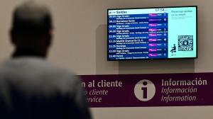 Una persona mira la pantalla, en la estación de tren de A Coruña