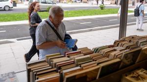 Uno de los primeros visitantes observa un ejemplar en la Feria del Libro Antiguo y de Ocasión