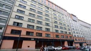 Dos personas cruzan el paso de peatones frente al número 12 de Ribeira Sacra