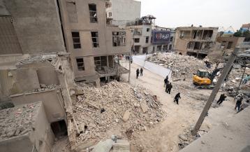 TEHRAN (Iran (Islamic Republic Of)), 15/03/2026.- Iranians walk amid damaged residential buildings in southern Tehran, Iran, 15 March 2026. A joint Israeli and US military operation continues to target multiple locations across Iran since the early hours of 28 February 2026. (Teherán) EFE/EPA/ABEDIN TAHERKENAREH