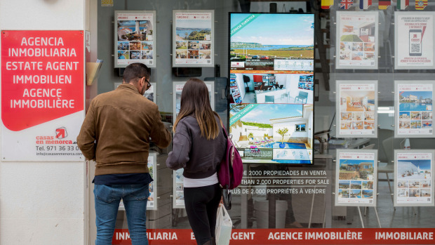 Dos personas miran las ofertas de una agencia inmobiliaria