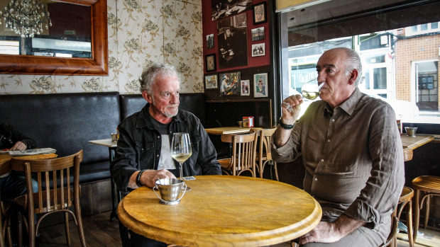 Pachi Ramos y Epi, amigos de la infancia y ahora jefe y empleado, conversan y toman algo en una mesa del Café Doré