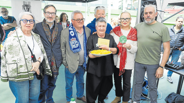 El jurado y la directiva de la asociación vecinal de la Sagrada Familia posan con la ganadora y su tortilla | germán barreiros