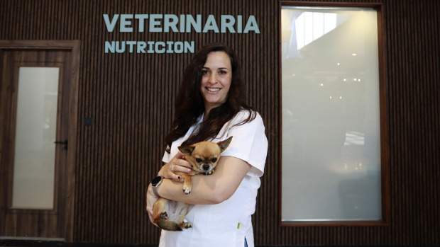 Ángela Vela posa con su perro delante de la clínica Avela Nutrición Veterinaria
