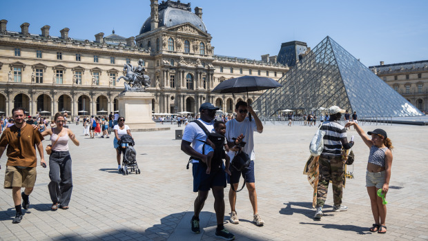 Personas caminan por la zona del Louvre en París