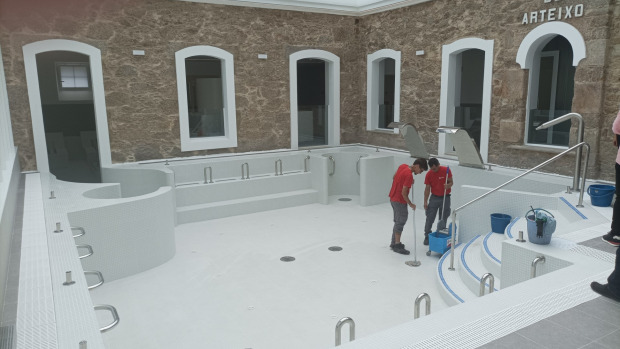 Dos operarios limpian la zona de baños