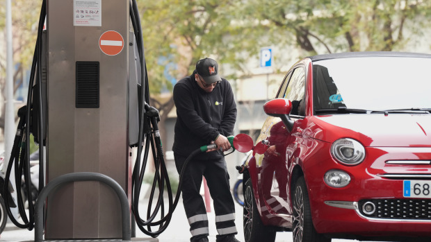 Una persona echa combustible en su vehículo