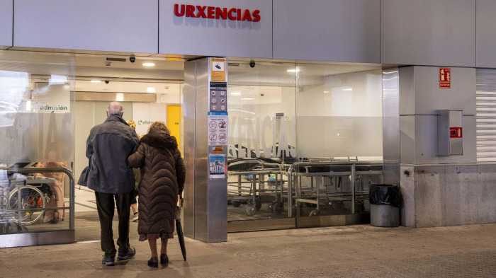 Dos personas en la entrada de Urgencias del Chuac