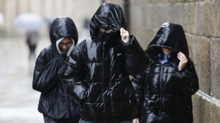 Varias personas se protegen de la lluvia en Santiago