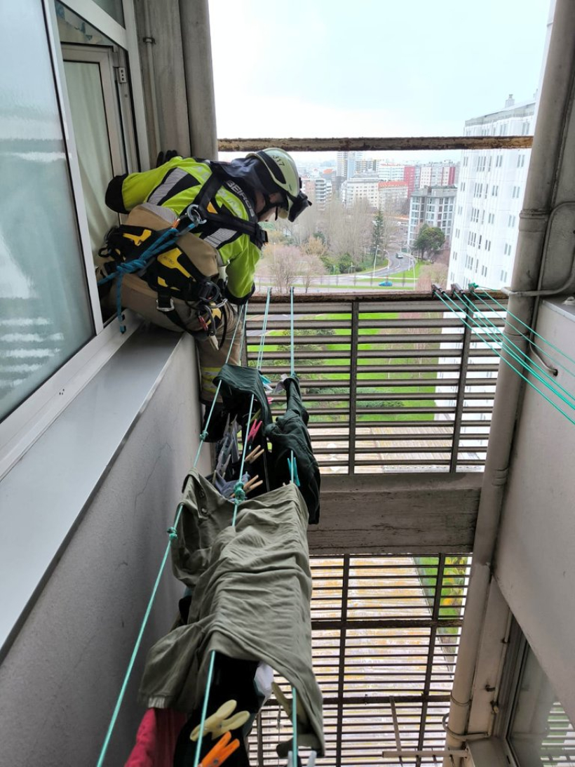 Un bombero participa en la intervención de la fachada en la plaza Luís Seoane