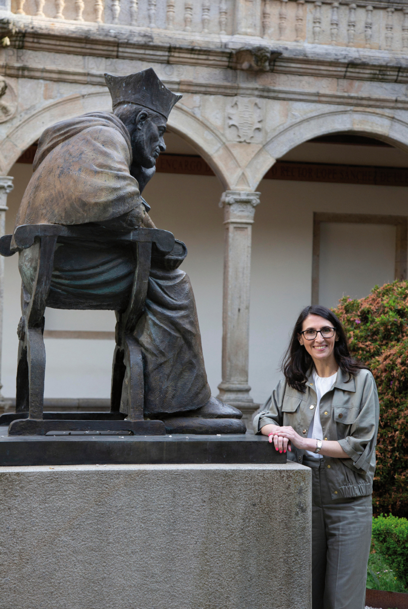 Rosa Crujeiras fronte a estatua do arcebispo Fonseca, nos exteriores do reitorado