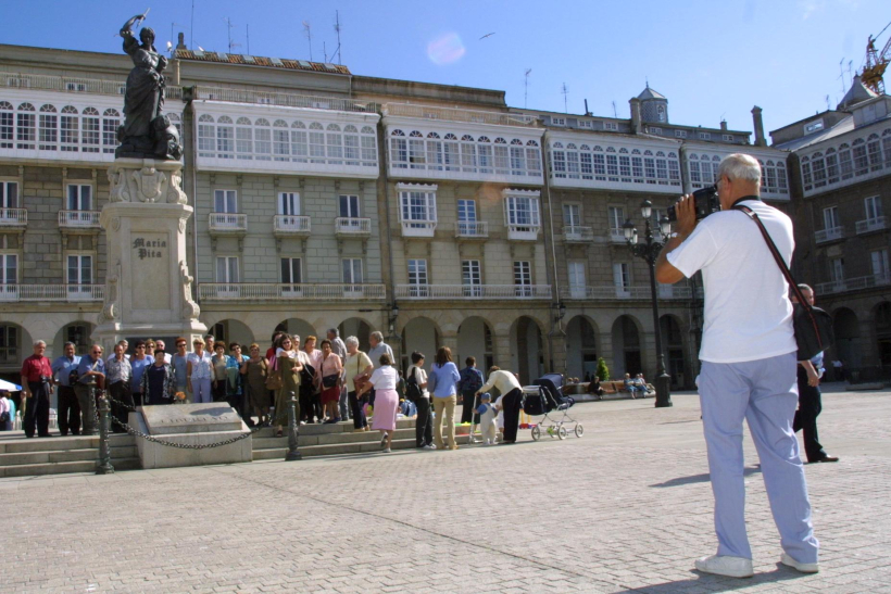 Un grupo de turistas hace un video a los pies de María Pita en junio de 2001