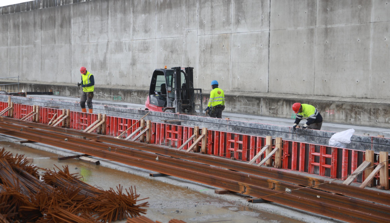 Operarios trabajan, ayer, en la colocación de los raíles de la red ferroviaria de la dársena de Langosteira