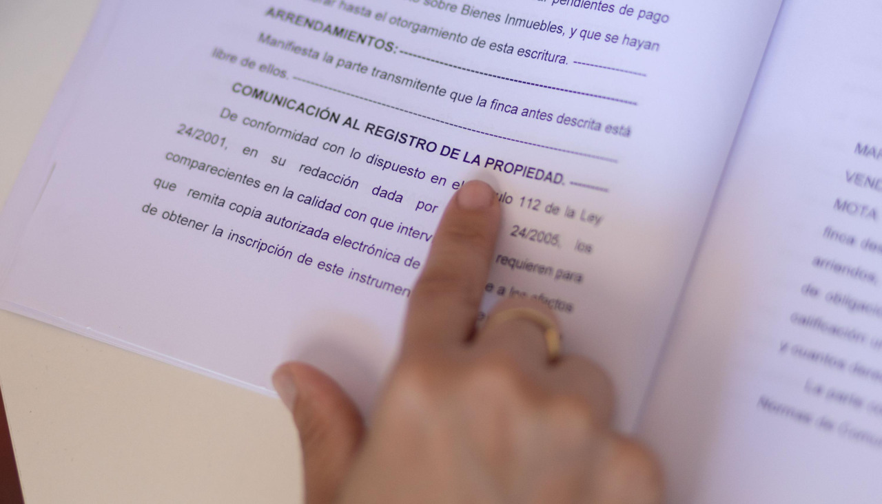 Una persona consulta la escritura de compraventa de una hipoteca