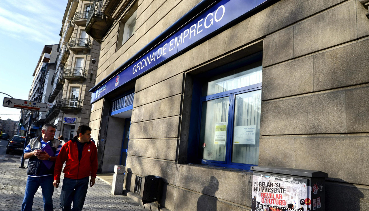 Dos personas caminan por delante de una oficina de empleo ubicada en Ourense