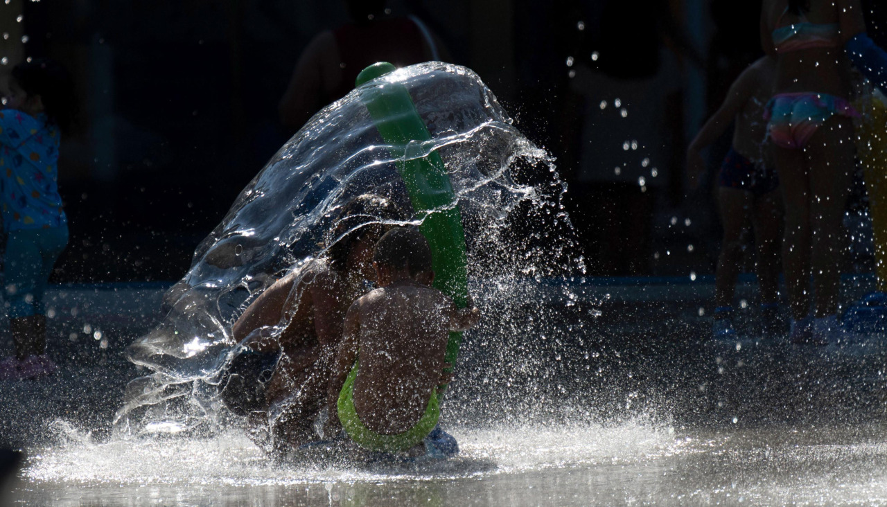 Dos niños se refrescan en un parque de Torrelavega