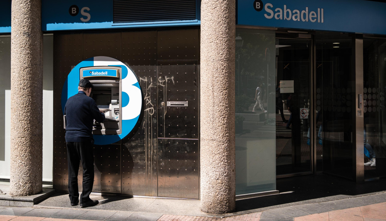 Una persona realiza operaciones en un cajero del Banco Sabadell
