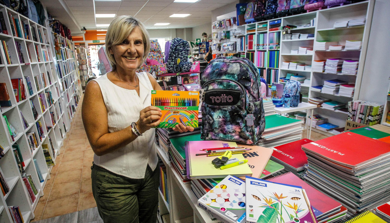 Fina Puñal, de la librería Clunia, junto a material escolar y libros