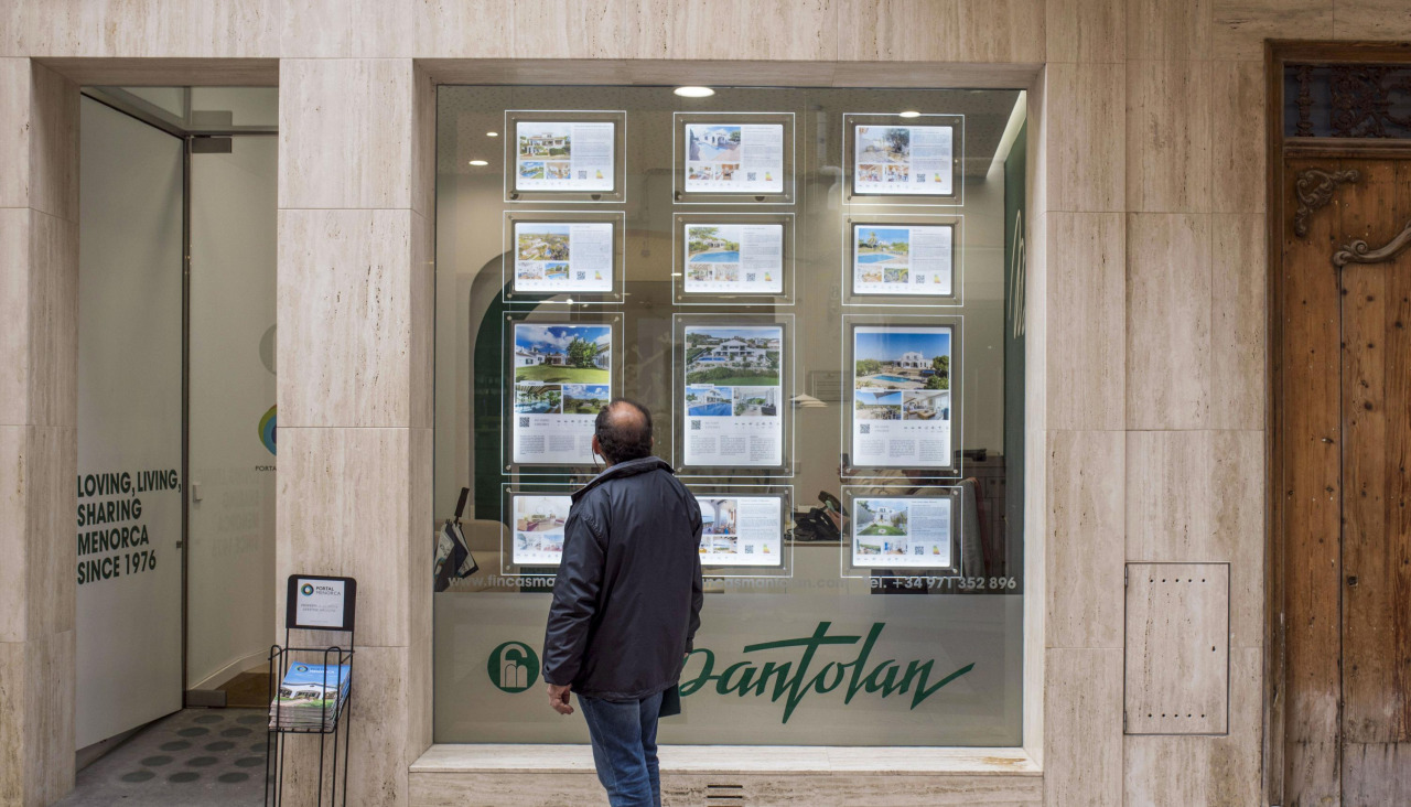 Una persona mira la oferta de una inmobiliaria en Mahón, Menorca