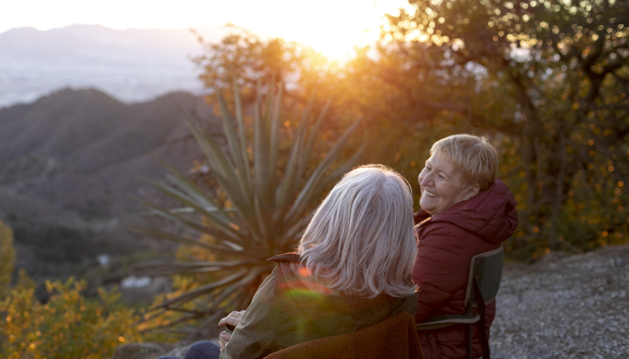 Dos mujeres mayores en una escapada la naturaleza sentadas en sillas y disfrutando de su tiempo