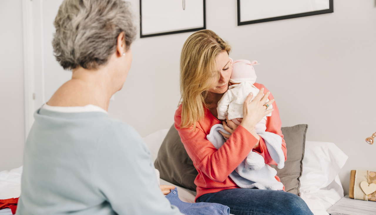 Madre sujetando bebe en la cama