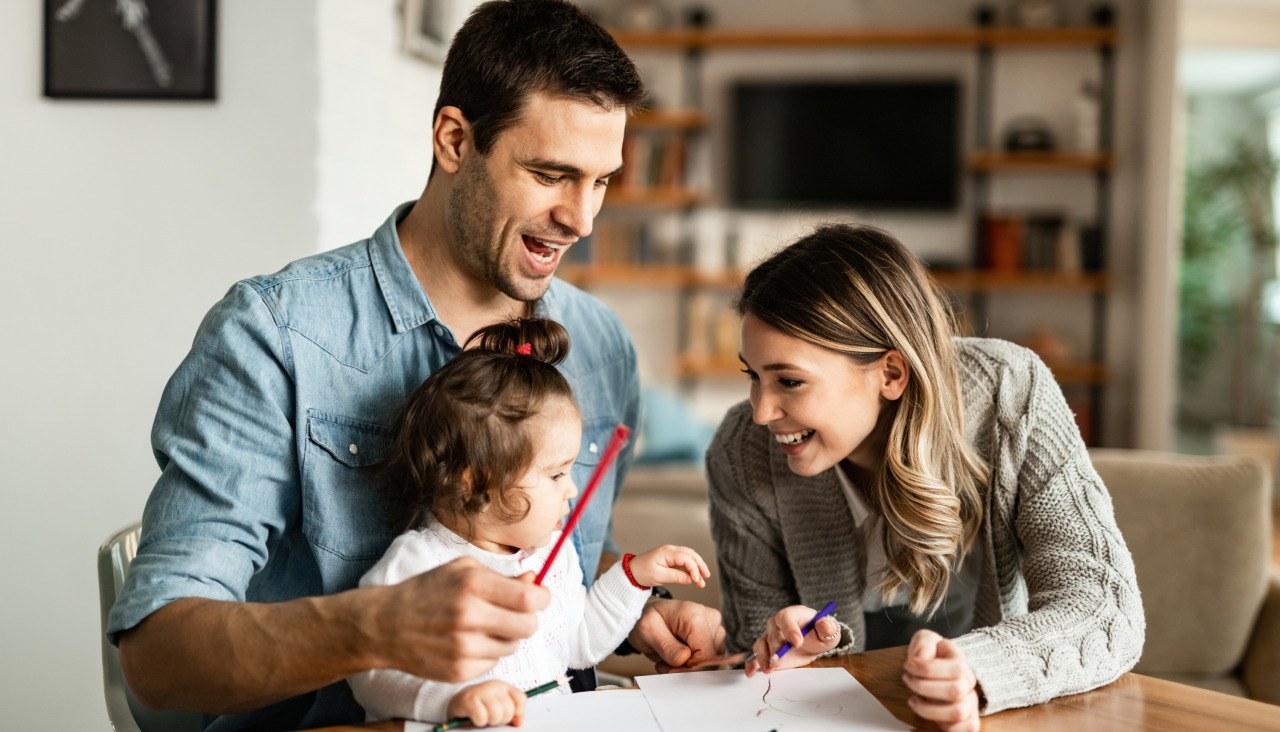 Felices padres y su pequena hija divirtiendose mientras colorean en el papel