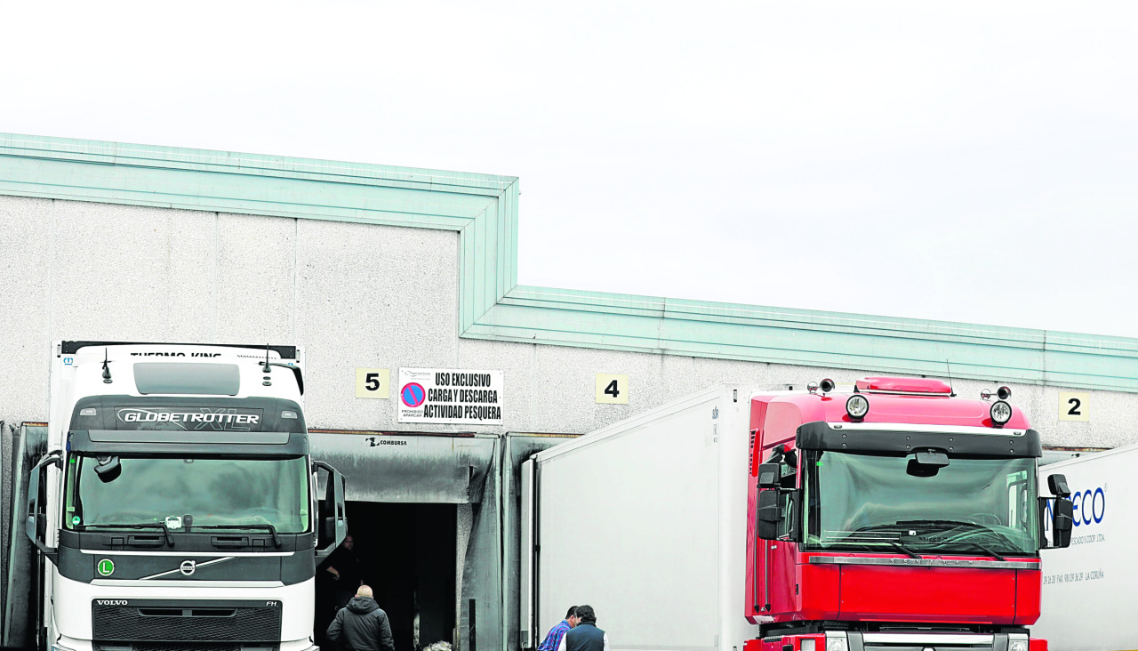 Camiones frigoríficos aparcados junto a una nave